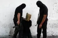 A Hamas militant grabs a Palestinian suspected of collaborating with Israel in Gaza City